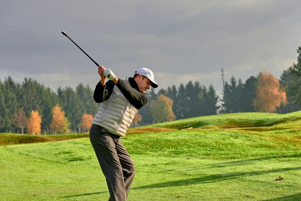 A man playing golf in an insulated vest