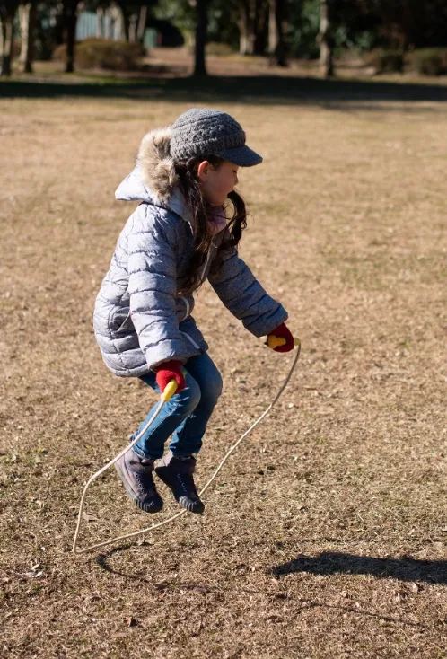 A child skipping rope in a down jacket