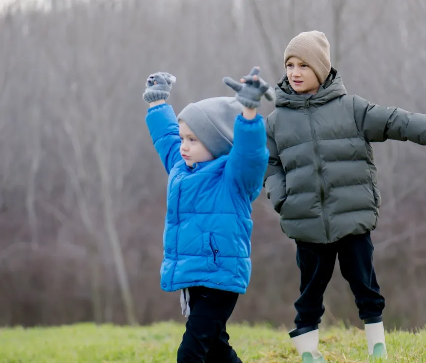 Children in down jackets playing energetically outdoors