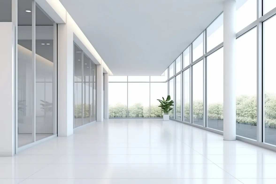 Bright office corridor lit through a full-height glass façade