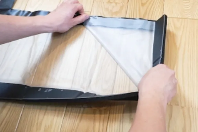 Folding the sheet along its diagonal to form a triangle