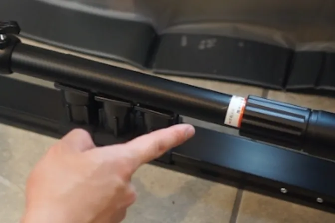 Pointing at the length-adjustment screw on the main unit